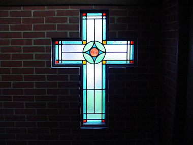 The stained glass window in the form of a cross in the vestibule of Redeemer Presbyterian.